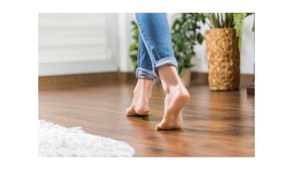a person's feet on a wood floor